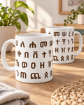 White ceramic mugs with wraparound Geez Fidel lettering